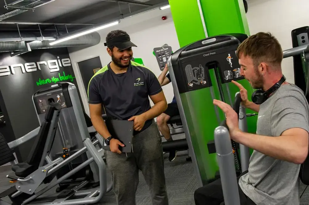 Personal training session at Energie Wellness Centre with certified trainer guiding client through equipment exercises